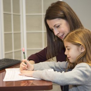Mother helping daughter with tutoring worksheets at home